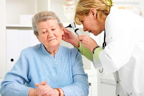 An Allertons audiologist in Garston, Liverpool checks the ears of a patient